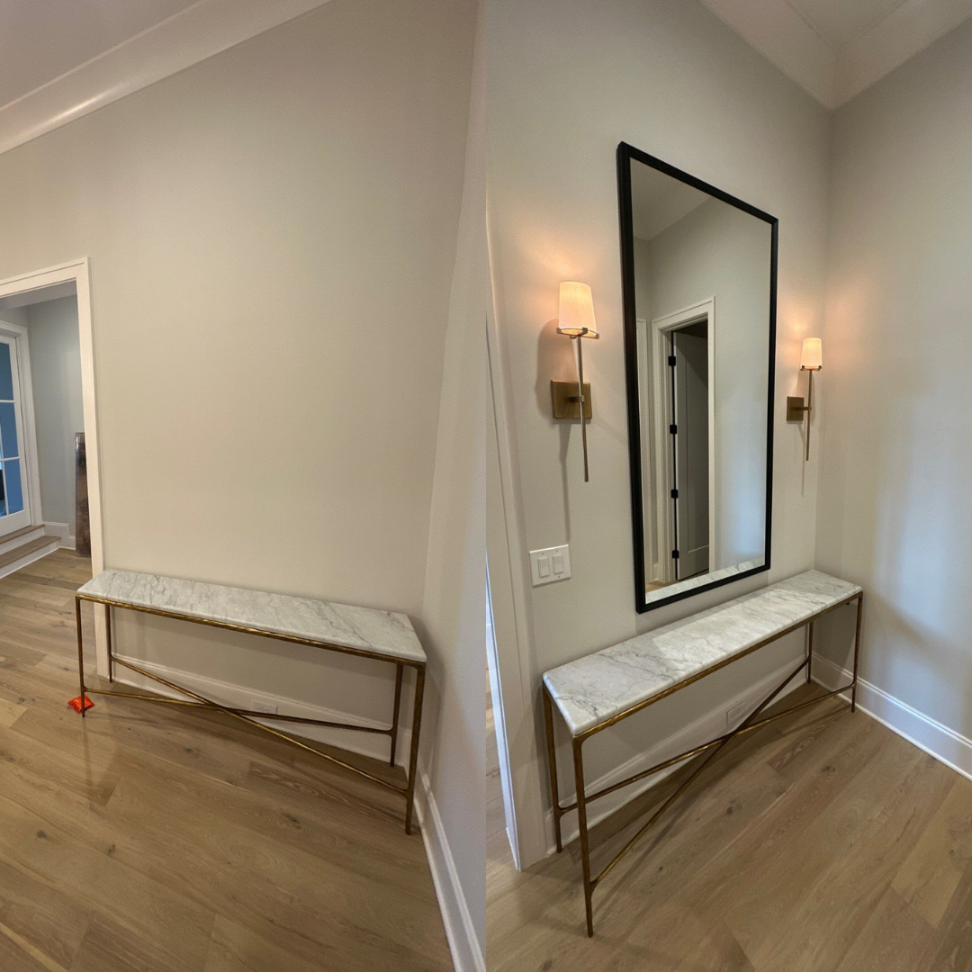 Hallway with a marble-topped console table, mirror, sconces, and hardwood floors.